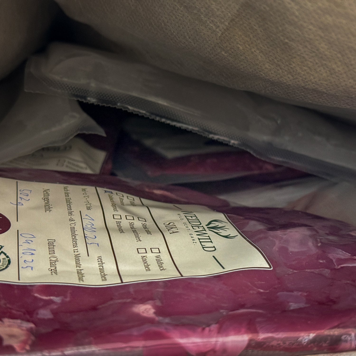 Vakuumverpacktes Sika Wildfleisch von Weidewild mit Etikett und Haltbarkeitsdatum aus den Bayerischen Staatsforsten.